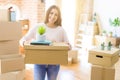 Beautiful young woman smiling happy moving to a new home, very excited holding cardboard boxes at new apartment Royalty Free Stock Photo