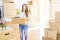 Beautiful young woman smiling happy moving to a new home, very excited holding cardboard boxes at new apartment Royalty Free Stock Photo