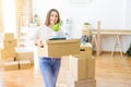 Beautiful young woman smiling happy moving to a new home, very excited holding cardboard boxes at new apartment Royalty Free Stock Photo