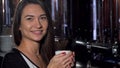 Beautiful young woman smiling, looking away dreamily, enjoying her coffee Royalty Free Stock Photo