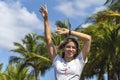 Beautiful young woman smiling raising her arms feeling happy