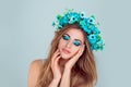 Woman posing with flowers on head blue eyeshadow closed eyes Royalty Free Stock Photo