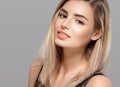 Beautiful young woman smiling posing with blond hair on gray background Royalty Free Stock Photo