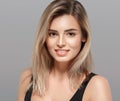 Beautiful young woman smiling posing with blond hair on gray background Royalty Free Stock Photo