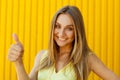 Beautiful young woman smiling and showing hand ok sign over yell