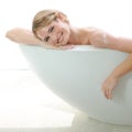 She enjoys pampering herself. A beautiful young woman smiling at you while enjoying a luxurious bath.