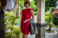 Beautiful young woman with snakeskin python leather handbag posing in sunglasses. Tropical Bali island, Indonesia. Royalty Free Stock Photo