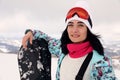 Beautiful young woman with snowboard on hill. Winter vacation Royalty Free Stock Photo