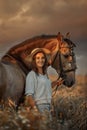 Beautiful young woman on spanish buckskin horse in rue field