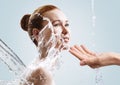 Beautiful young woman in splashes of clear water.