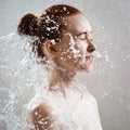 Beautiful young woman in splashes of clear water.