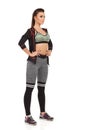 Beautiful Young Woman In Sports Clothes Is Standing With Hand On Hip. Front Side View. Royalty Free Stock Photo