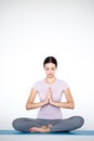 Beautiful young woman in sportswear practicing yoga while sitting in lotus position on white background Royalty Free Stock Photo