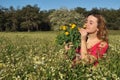 Beautiful young woman standing in blooming meadow