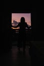 Beautiful young woman standing in doorway at sunset Royalty Free Stock Photo