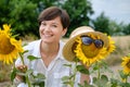 A beautiful young woman is standing in a field of sunflowers in the summer. Royalty Free Stock Photo