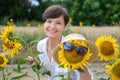 A beautiful young woman is standing in a field of sunflowers in the summer. Royalty Free Stock Photo