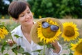 A beautiful young woman is standing in a field of sunflowers in the summer. Royalty Free Stock Photo