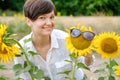 A beautiful young woman is standing in a field of sunflowers in the summer. Royalty Free Stock Photo