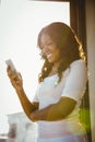 Beautiful young woman standing in front of a window Royalty Free Stock Photo