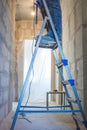 Beautiful young woman standing on ladder doing wall painting. mixed race asian chinese female model