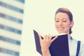 Beautiful young woman standing reading a book outdoors Royalty Free Stock Photo