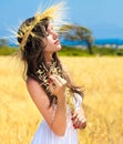 A woman standing in the field with a wreath