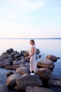 Beautiful Young Woman Staying on Seashore Stones