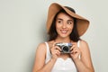 Beautiful young woman with hat and camera on light grey background, space for text. Stylish headdress Royalty Free Stock Photo