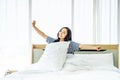 Beautiful young woman stretching in bed with her arms raised after wake up,  Healthy lifestyle, Wellness concept Royalty Free Stock Photo
