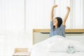 Beautiful young woman stretching in bed with her arms raised after wake up,  Healthy lifestyle, Wellness concept Royalty Free Stock Photo