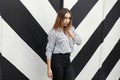 Beautiful young woman in striped blouse near the wall with lines Royalty Free Stock Photo