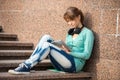 Beautiful young woman student with note pad and headphones. Outdoor student. Royalty Free Stock Photo