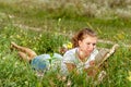 Beautiful young woman-student reading a book lying on the grass. Pretty girl outdoors in summertime Royalty Free Stock Photo