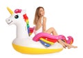 Beautiful young woman in stylish bikini with  unicorn inflatable ring on white Royalty Free Stock Photo