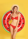 Beautiful young woman in stylish bikini with watermelon inflatable ring