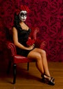 Beautiful young woman with sugar skull surounded by red Royalty Free Stock Photo