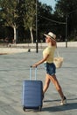 Beautiful young woman with suitcase and wine glass waiting a ship for summer trip. Curly hair happy woman with backpacks on the pi Royalty Free Stock Photo