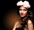 Beautiful Young Woman with Summer Pink Flowers. Long Permed Curly Hair and Fashion Makeup. Beauty Girl with Flowers Royalty Free Stock Photo