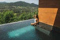 Beautiful young woman sunbathing and relaxing on edge private pool Royalty Free Stock Photo