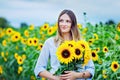 Beautiful young woman on sunflower field with bouquet flowers. Happy girl on summer sunset day. Royalty Free Stock Photo