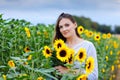 Beautiful young woman on sunflower field with bouquet flowers. Happy girl on summer sunset day. Royalty Free Stock Photo