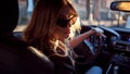 Beautiful young woman in sunglasses sitting behind the wheel of a car. Photo from the back seat Royalty Free Stock Photo
