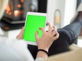 Young woman using tablet computer in front of fireplace Royalty Free Stock Photo