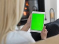 Young woman using tablet computer in front of fireplace Royalty Free Stock Photo