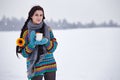 Beautiful young woman in a sweater on a winter walk with a cup o Royalty Free Stock Photo