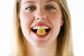 Beautiful young woman with a sweet candy in mouth looking at camera over white background. Royalty Free Stock Photo