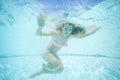 Beautiful young woman swimming underwater in pool. Royalty Free Stock Photo