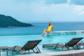 Beautiful young woman in swimwear relaxes in infinity pool at a luxury spa resort Royalty Free Stock Photo