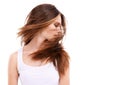 Her hair is filled with body and life. A beautiful young woman swooshing her hair against a white background.